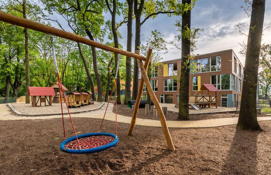 Kindergarten am Filmpark - Spielplatz der Kita "Ole Lukoie" mit Blick auf das Kita-Gebäude