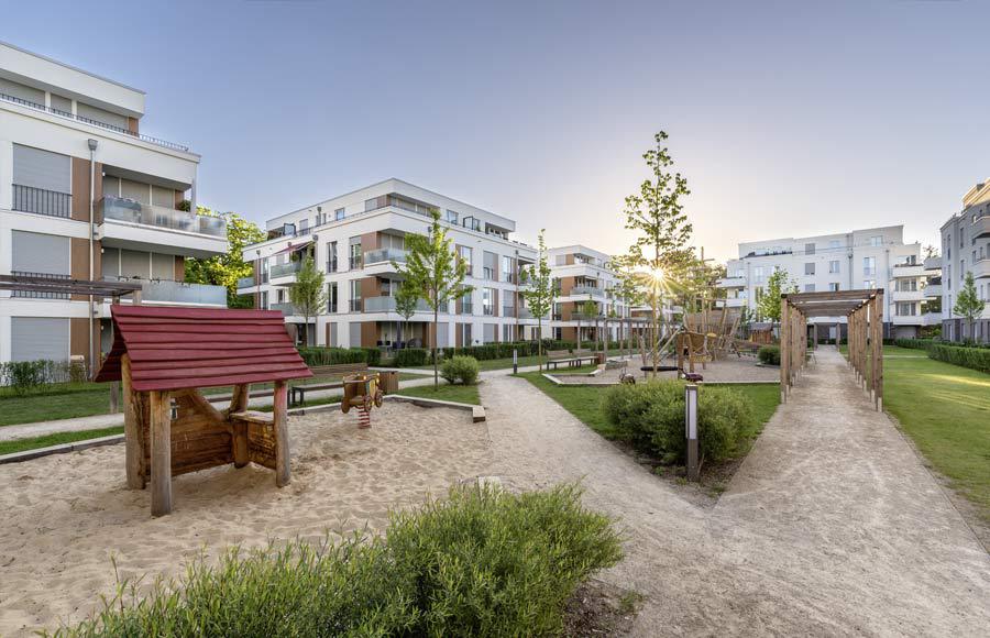 Villen am Filmpark Babelsberg - Blick in den gestalteten Hof zwischen den Stadtvillen mit grünen Freiflächen, Gärten und Kinderspielplatz bei Sonnenaufgang
