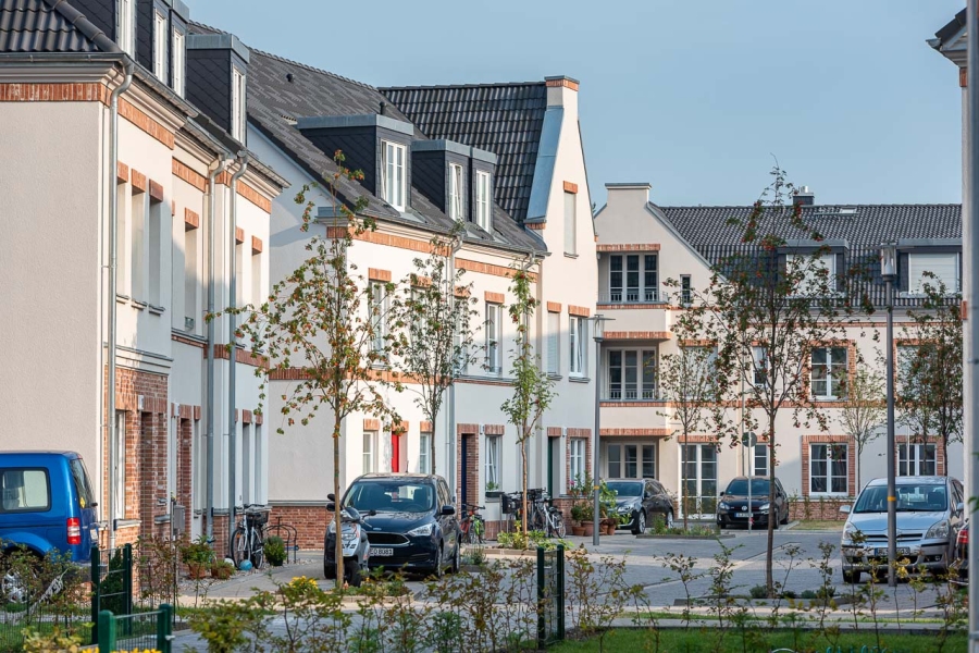 Grüne Aue Biesdorf Impression aus Wohngebiet mit Blick auf Reihen- und Mehrfamilienhäuser, parkende Autos davor