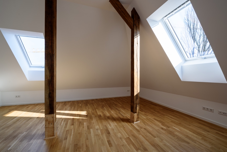 Wohnzimmer mit erhaltenen Holzbalken in saniertem Denkmal